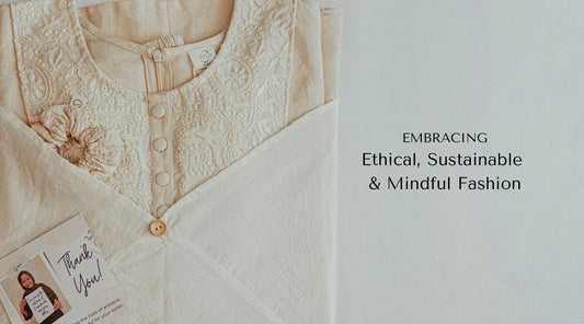 Hand embroidered linen top placed on a white table with text on the side that reads "embracing ethical, sustainable & mindful fashion"
