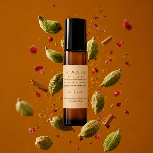 Mooshq perfume bottle with cardamom pods and rose petals on an orange background
