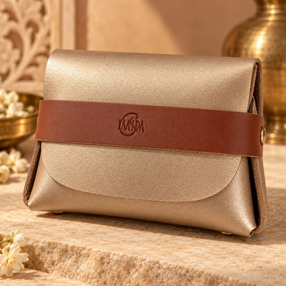 Gold pouch with brown strap that say Kaasida