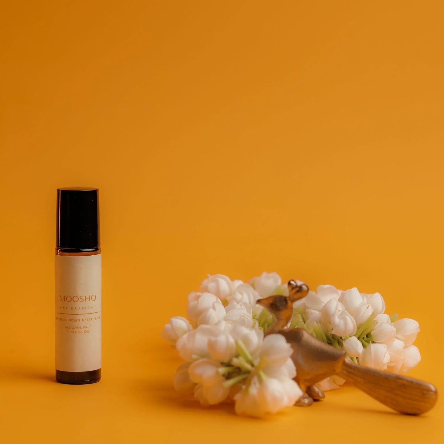 Perfume Oil bottle with jasmin flowers on a yellow background