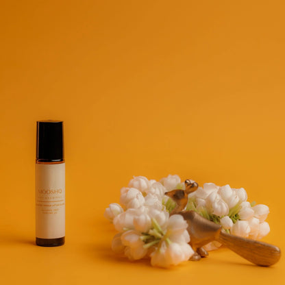 Perfume Oil bottle with jasmin flowers on a yellow background