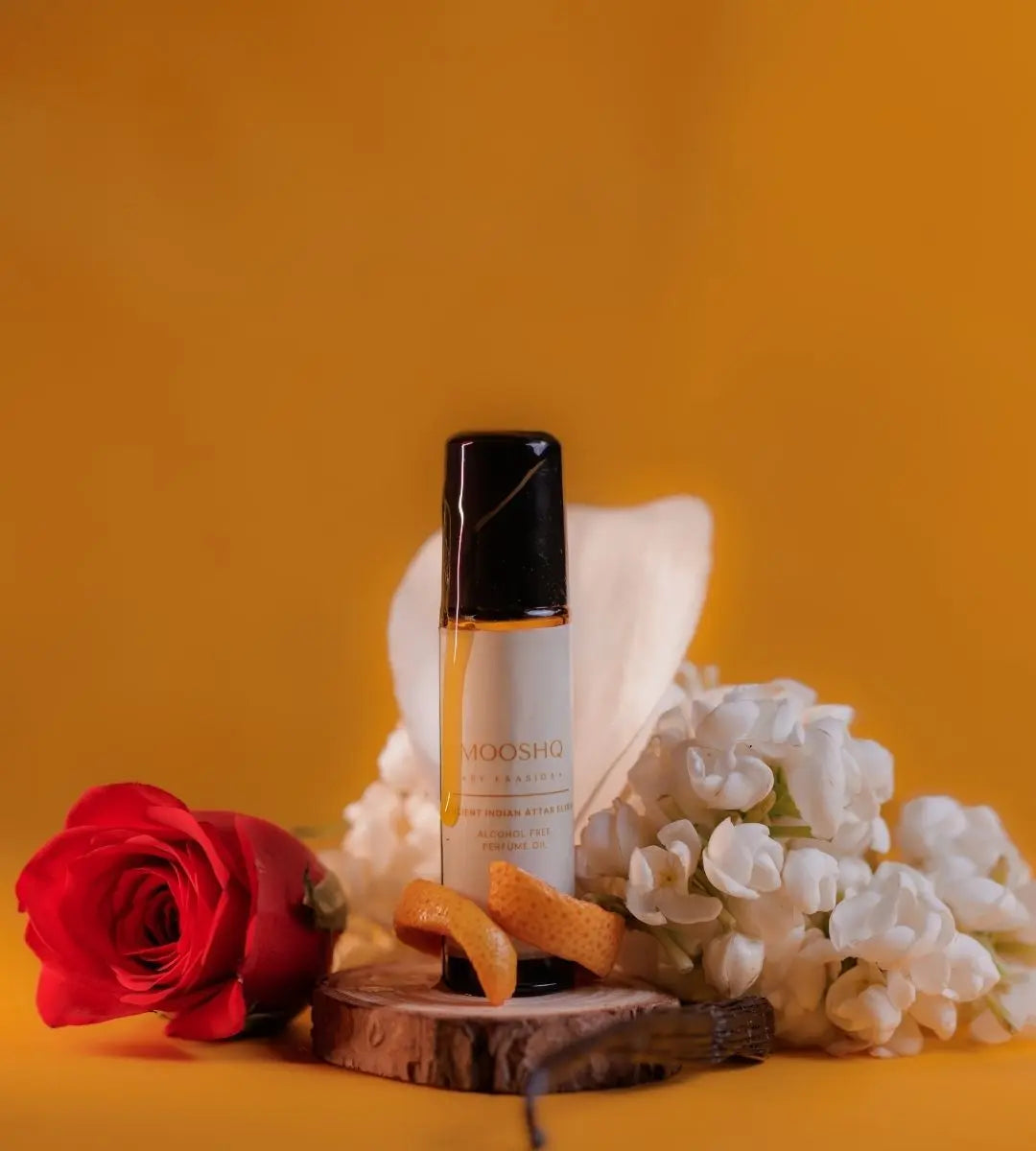 Perfume Oil bottle with flowers and a rose on an orange background