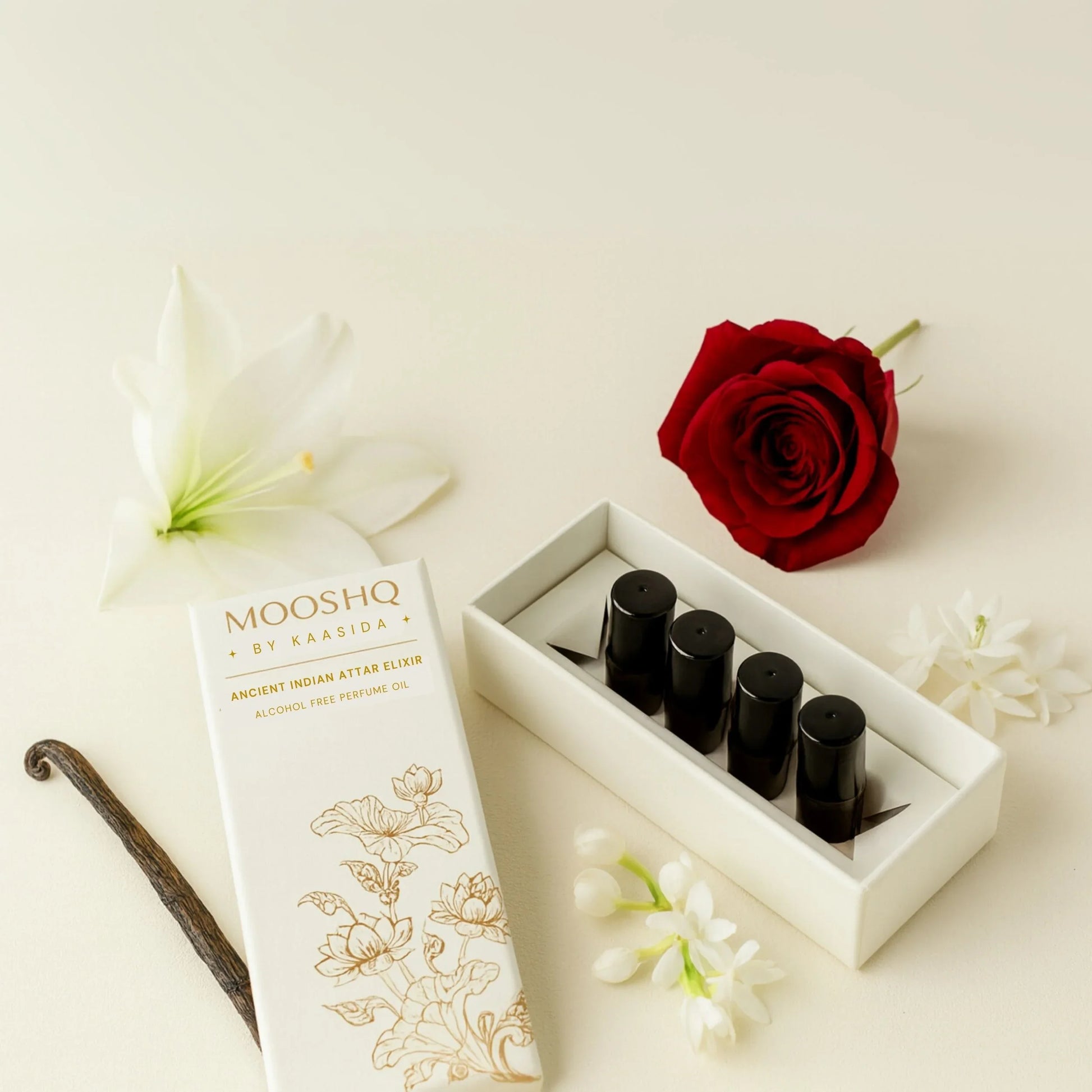 Mooshq Perfume Oil bottles in black colour and a red rose on a light background