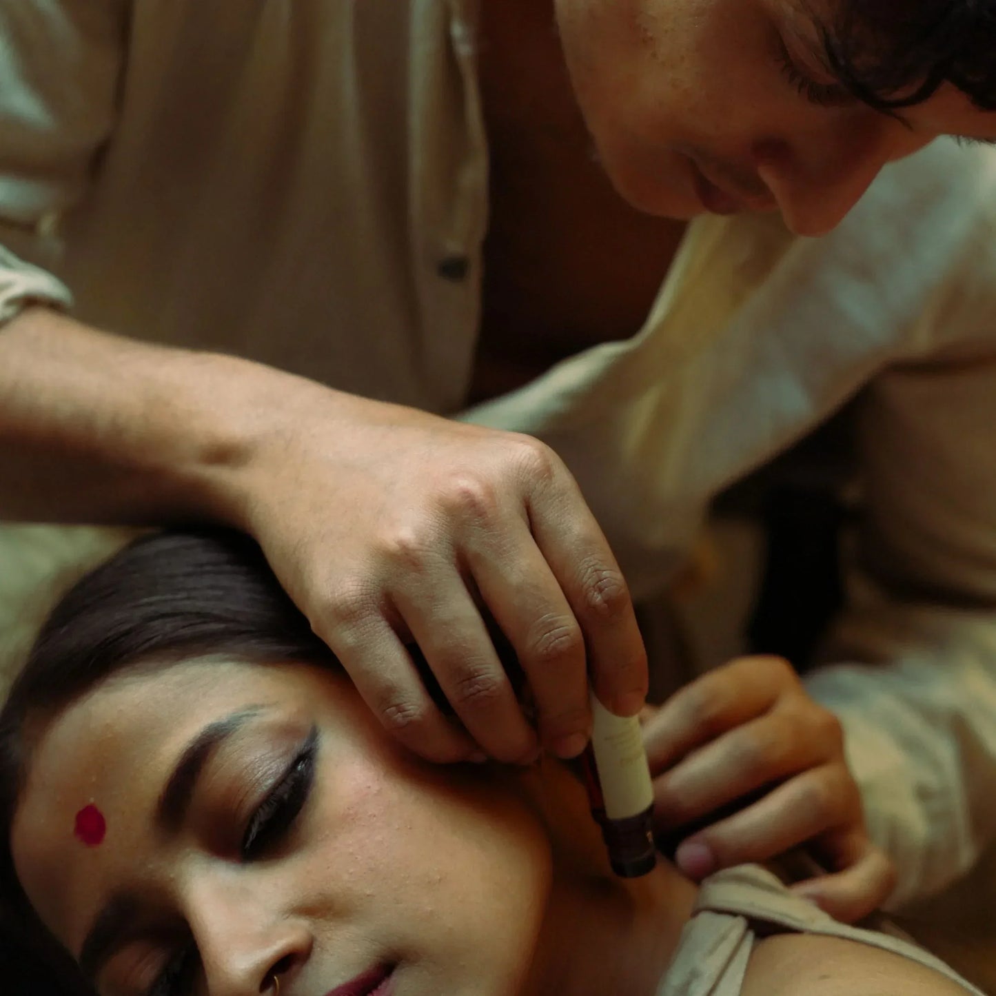 Person applying mooshq perfume oil to another person's neck 