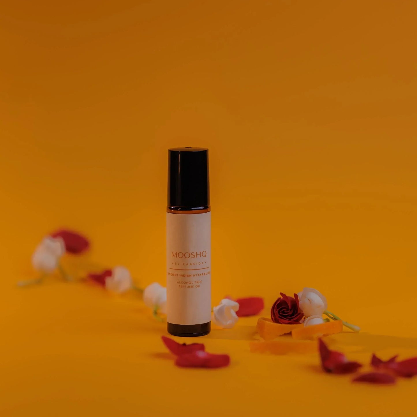 Perfume Oil bottle with flowers on an orange background